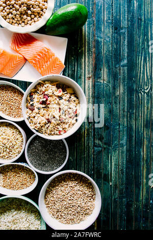 Abwechslungsreiche Auswahl von unverarbeitetem Getreide auf Schalen, Ansicht von oben flach, Linsen, Bulgur und Quinoa, Hanfsamen, Sonnenblumenkerne, brauner Reis, Reis, mit einem voll von guten Fetten Stockfoto