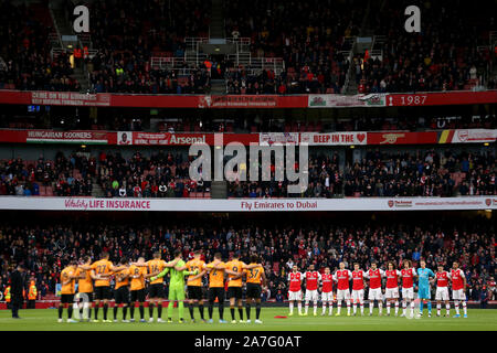 Beide Teams beachten Sie die Minuten Stille vor der Premiership match Im Emirates Stadium, London. Stockfoto