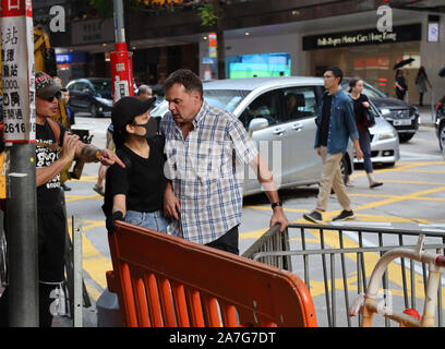 Hongkong, China. 02 Nov 2019. (191102) - Hong Kong, November 2, 2019 (Xinhua) -- ein Mann stellt eine schwarz gekleidete und maskierte Frau an der Queen's Road East in Hong Kong, South China, November 2, 2019. Schwarz gekleidete illegalen Demonstranten blockierten Strassen und Verkehr an der Queen's Road East am Samstag gestört. Ein Mann trotzte die illegalen Demonstranten die Barrikaden aus dem Weg zu räumen. (Xinhua) Quelle: Xinhua/Alamy leben Nachrichten Stockfoto