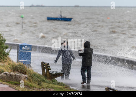 Southend On Sea, Essex, Großbritannien in die Mündung der Themse war festgezurrt mit Wind und Regen vor dem Sturm vor Überquerung des Landes. Menschen genossen zu Fuß entlang der Strandpromenade dennoch als Wellen auf das Meer Wand abgestürzt. Folgen des Hurrikans Pablo Stockfoto