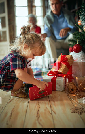 Süße Mädchen offen Vor einem geschmückten Weihnachtsbaum Stockfoto