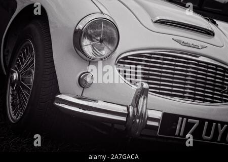 Rechte vordere Viertel eines klassischen Vintage Austin Healey 3000 Sport Auto in Schwarz und Weiß mit einem grobkörnigen Film Effekt. Übersicht Scheinwerfer, Radi Stockfoto