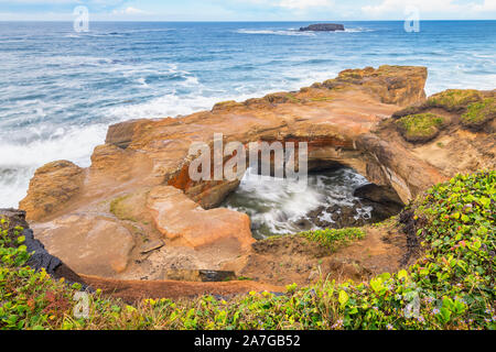 Devil's Punch Bowl in Otter Rock, Oregon, USA. Es ist eine große Schüssel natürlich in einem Rock Landspitze teilweise offen zum Pazifischen Ozean geschnitzt. Stockfoto