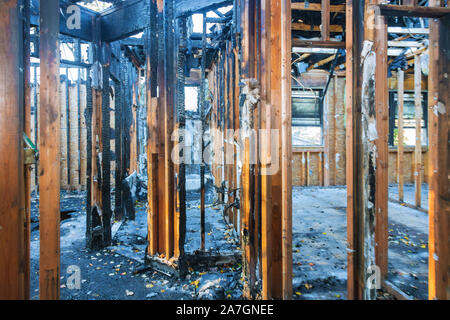 Verbrannte Holz- wände Haus mit verkohlten Dach brannte Feuer details im Innenraum beschädigt Stockfoto