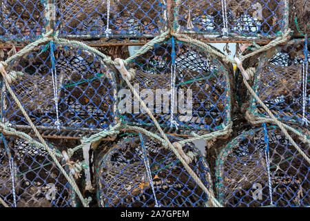 Hummer und Krabbentöpfe stapeln sich bereit für die Verwendung durch Fischer auf der Quayside an der Küste von norfolk, East Anglia, Großbritannien. Stockfoto