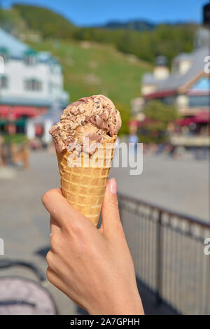 Weibliche hand Eis mit Schokoladensauce und Cookies, in der Nähe Stockfoto