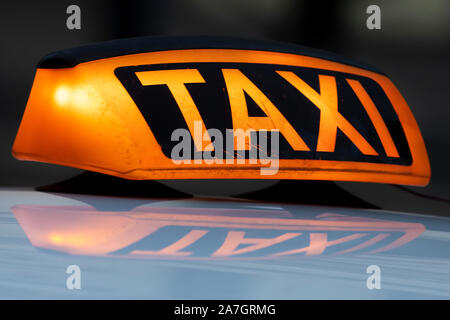 Taxi Schild auf dem Dach eines Autos im Zentrum einer Stadt Stockfoto