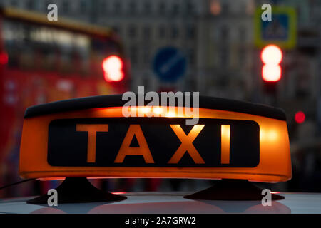 Taxi Schild auf dem Dach eines Autos im Zentrum einer Stadt Stockfoto
