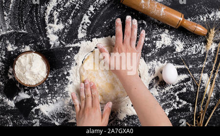 Frau kneten den Teig für die Pizza zu Hause Stockfoto