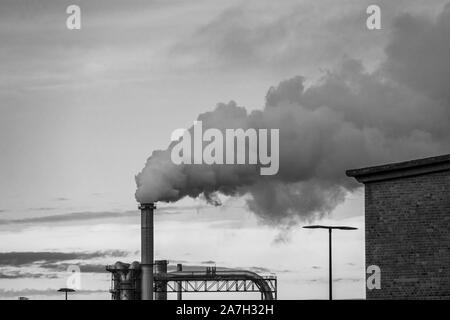 Viel Rauch und Dämpfe kommen aus einer industriellen Schornstein Stockfoto