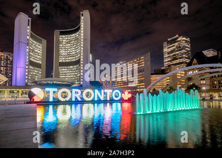 Nathan Phillips Square bei Nacht mit Toronto unterzeichnen und Rathaus Gebäude Stockfoto