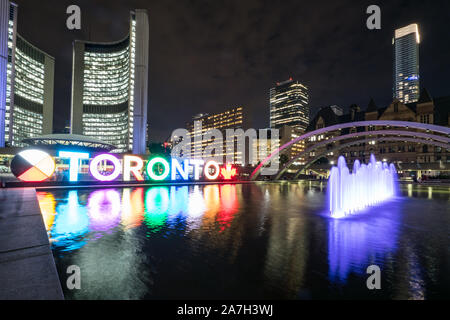 Nathan Phillips Square bei Nacht mit Toronto unterzeichnen und Rathaus Gebäude Stockfoto