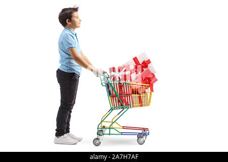 Volle Länge Profil Schuss ein Junge mit einem Einkaufswagen voller eingepackten Geschenke auf weißem Hintergrund Stockfoto