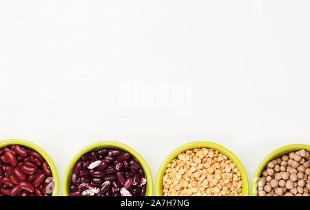 Bunte Hülsenfrüchte in Schalen. Bohnen, Kichererbsen, Erbsen auf weißem Hintergrund, Ansicht von oben mit der Kopie. Stockfoto