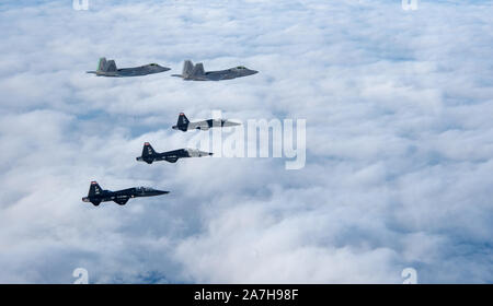 F-22 Raptors und T-38 Talons vom 1 Fighter Wing fliegen in Formation auf den Atlantischen Ozean während der Ausbildung an der Küste von Virginia, Okt. 30, 2019. Die 1 Fighter Wing ist die Heimat der 94th Fighter Squadron, 27 Fighter Squadron und der 71St Fighter Training Squadron bei Joint Base Langley-Eustis (USA, Virginia. Air Force Foto von Tech Sgt. Carlin Leslie) (freigegeben) Stockfoto