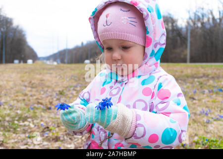 Mädchen, die ersten Schneeglöckchen Blumen in den Händen Stockfoto