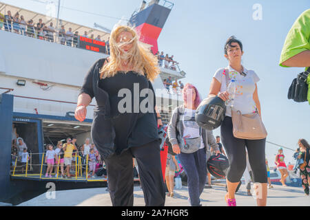 Skiathos Griechenland - 4. August 2019; Leute auf und kommen und gehen von der griechischen Insel Fähre am Wharf auf Skiathos. Stockfoto