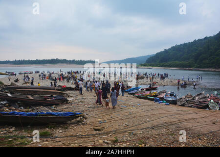 Dawki, Shillong, Meghalaya, 16. Juni, 2019: Touristen, bunte Boote aus Holz, Umngot Fluss in dawki von Shillong, Meghalaya mit dem Himmel und Hügel Stockfoto