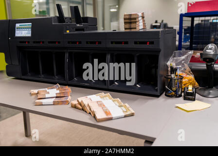 Banknoten gestapelt und zusammen mit Währung Bands vor der elektronischen Zählmaschine gebunden Stockfoto