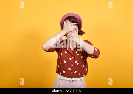 Junge Frau mit Augen und Mund mit den Händen, überrascht, schockiert Stockfoto