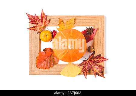 Bilderrahmen mit Herbstlaub, Quitte und orange Kürbis. Kreative Thanksgiving oder Halloween Konzept. Flach Stockfoto