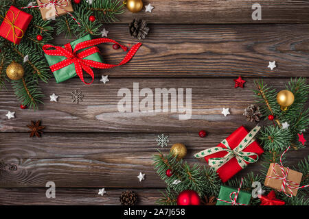 Weihnachten und ein glückliches Neues Jahr. Tanne Baum mit roten Urlaub Dekorationen und Geschenkboxen auf rustikalen Holztisch. top anzeigen. Flachbild mit Laien Stockfoto