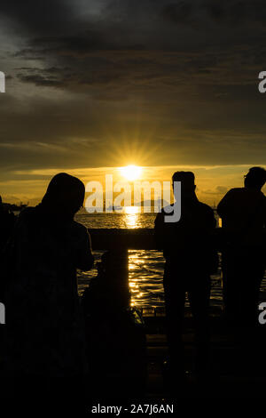 Ein paar Leute in den Schatten fotografieren der Sonnenuntergang Stockfoto