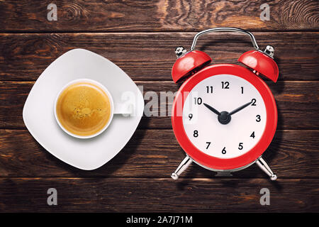 Tasse Espresso und vintage Alarm Clock auf Holztisch, Ansicht von oben Stockfoto