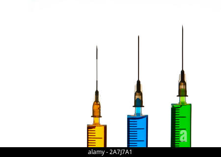 3 Spritze mit bunten Flüssigkeiten auf isolierten weißen Hintergrund gefüllt Stockfoto