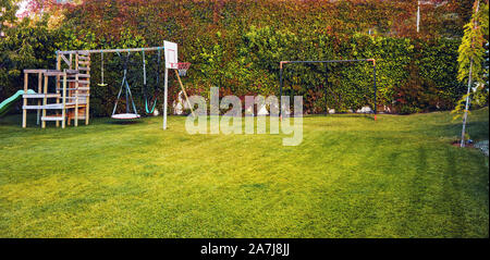 Garten im Hinterhof eines Hauses mit Kinderspielhaus, Basketballkorb und Fußballtor post Stockfoto