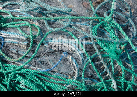 Ein kabelsalat Fischernetze Kunststoff Seil und andere Ablagerungen auf einer Küste Strand ideal für eine ökologische Gefährdung oder Verunreinigung Konzept gewaschen Stockfoto