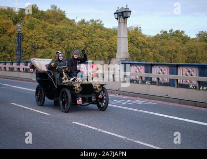 London, Großbritannien. 3rd. November 2019. Teilnehmer fahren einen Peugeot aus dem Jahr 1904 über die Themse auf der Lambeth Bridge, die vom Westminster Palace übersehen wird, bei der diesjährigen Ausgabe des Bonhams London to Brighton Veteran Car Run. Stockfoto