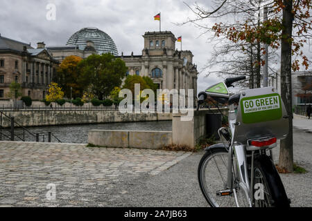 Electric City Fahrräder über verschwommenes Reichstag Hintergrund, ökologische Kultur Stockfoto