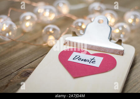 Geben Dienstag liebe Konzept mit Text und Bargeld, Kreditkarten auf Holzbrett spenden Stockfoto