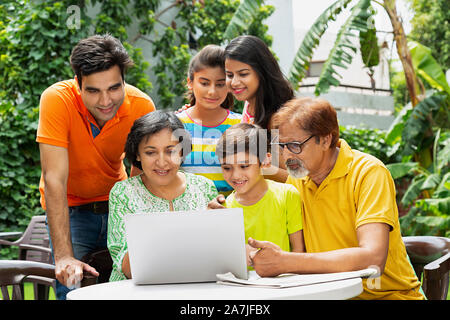 Gerne große Familie Großeltern, Eltern und Kinder gemeinsam - am Laptop Screen Video Chat In-home Garten Stockfoto