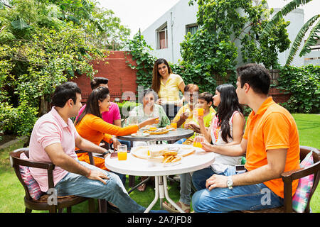 Group-Of Glücklich drei Generation Familie essen Frühstück gemeinsam im Innenhof in der Nähe Ihres Hauses Stockfoto