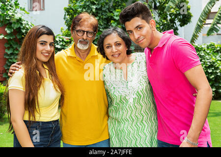 Happy Family älteren Eltern und erwachsene Sohn mit Schwiegertochter stehen miteinander im Innenhof in der Nähe Ihres Hauses Stockfoto