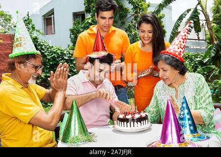 Glücklich nach Familie älteren Eltern und Erwachsene Kinder feiern Geburtstag im Innenhof ihres Hauses Stockfoto