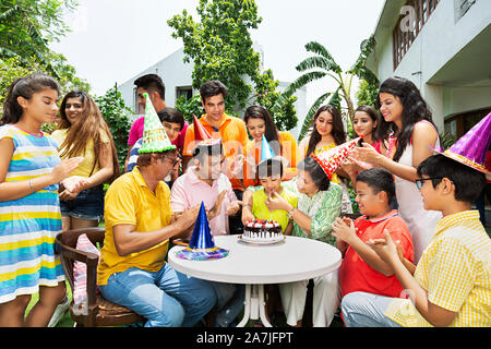 Große Gruppe - glückliche Familien Mitglieder feiern gemeinsam kleine Junge Geburtstag im Innenhof ihres Hauses Stockfoto