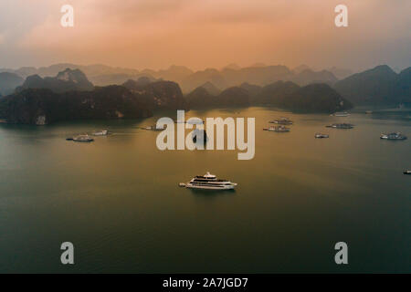 Luftaufnahme von Ha Long Bay in Vietnam bei einem schönen Sonnenuntergang mit Ruhe, ruhige See und viele der neuen Luxus Kreuzfahrtschiffe in der Bucht Stockfoto