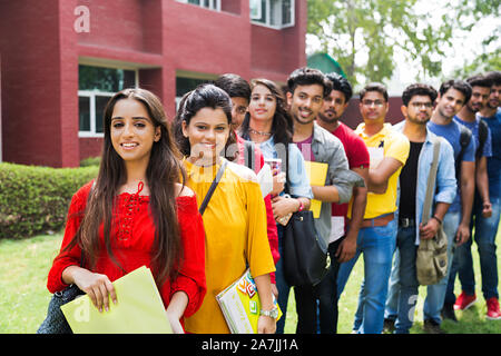 Gruppe von Jungen und Mädchen College-Students Freunde stehen zusammen In-Queue In-Outside Camous Gebäude Stockfoto