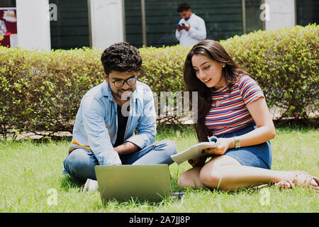 Zwei junge Studenten Freunde Studium Buch mit Laptop In-Outside Campus Stockfoto