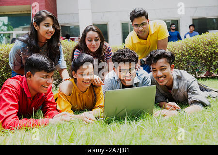 Gruppe von College Mädchen und Jungen Studenten Freunde zusammen Looking-At Laptop Bildschirm In-Outside Campus Stockfoto