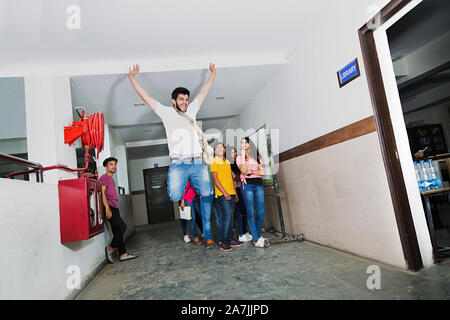 Junge Studenten Springen feiern ihr Ergebnis mit Mitschülern in-College Campus Stockfoto