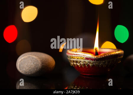 Niemand schoß Brennen Diya öl-Lampe mit Stein Beleuchtung während Diwali Fest Feier Stockfoto