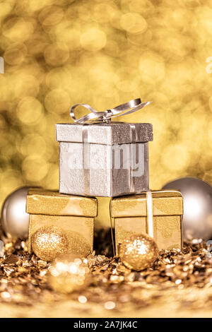 Drei Gold und Silber glänzende Geschenke mit goldenen Funkeln Stockfoto