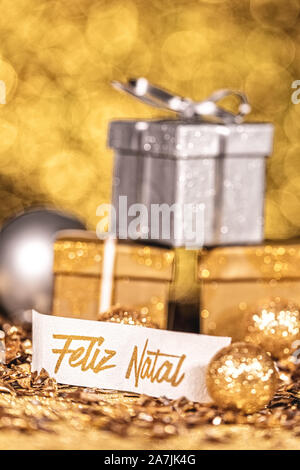 Drei Gold und Silber glänzende Geschenke mit goldenen funkelt und portugiesische Text Feliz Natal, das heißt frohe Weihnachten Stockfoto