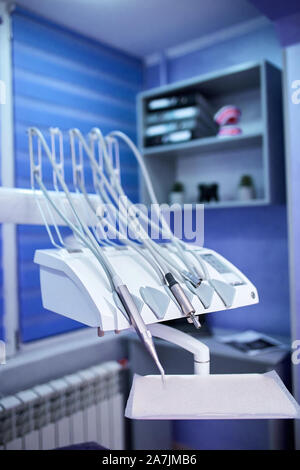 Modernen metallischen Zahnarzt Werkzeuge und Poliermaschinen auf einem Zahnarztstuhl in Zahnarzt Klinik. Andere zahnärztliche Instrumente und Werkzeuge in einem Zahnarztbüro. Stockfoto
