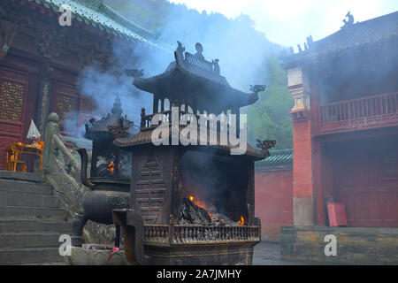 Massen beten für Segen mit Feuer und Rauch innen Einer der Tempel der Wudang Stockfoto