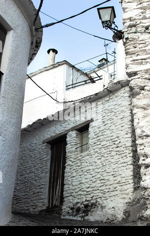 Blick auf den Backstein Fassaden in der Ecke eines kleinen und ländlichen Dorf. Straße der kleine und alte Stadt in der Landschaft von Granada, Spanien. Stockfoto